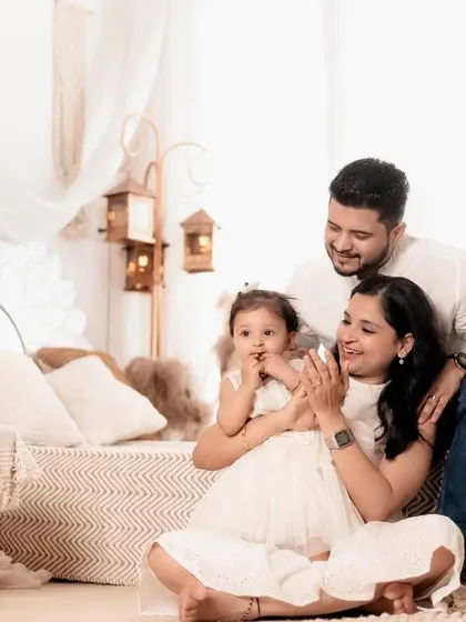 A happy family enjoying their time together in the studio. The little girl's shy smile is absolutely precious in this light-filled, candid photo.