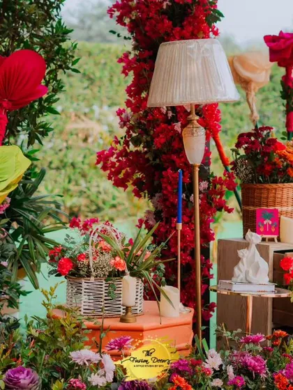 A garden of delights! This setup is filled with oversized paper flowers, fresh floral arrangements in baskets, and unique lamps, creating a whimsical and enchanting atmosphere.