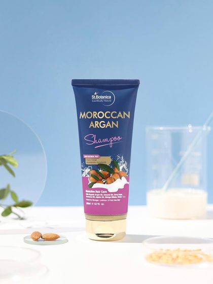 A scientifically inspired setup for a Moroccan Argan shampoo. The use of beakers and petri dishes, combined with a clean blue background, communicates that the product is both natural and effective.