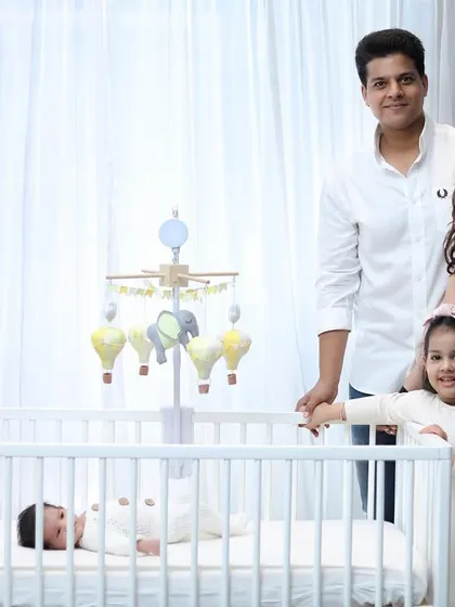 A lovely family portrait with the parents and older sister looking towards the camera. This shot is perfect for announcements or framing in the family home.