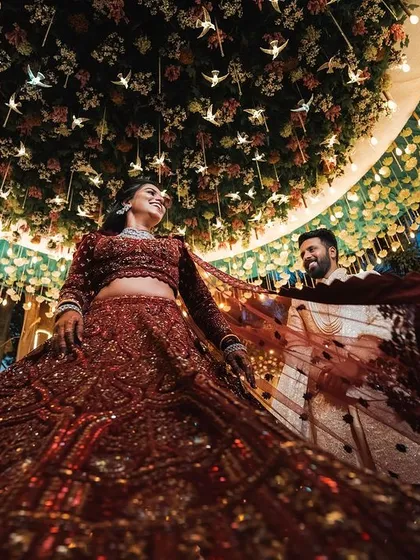 The bride twirls in her magnificent red lehenga during the sangeet. This shot captures the energy, the stunning decor, and the sheer joy of the celebration.