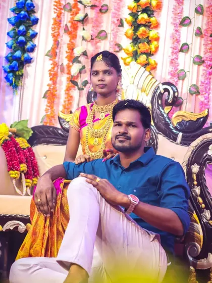 A stylish portrait of the couple seated on the wedding stage. The groom's relaxed pose complements the bride's graceful presence, showcasing them as a confident and happy pair.