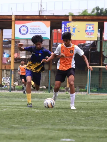 Our player shields the ball from a defender, showcasing strength and control.