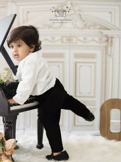 A playful shot of a one-year-old boy trying to play the piano. Our milestone sessions are all about capturing the curious and fun-loving nature of toddlers.