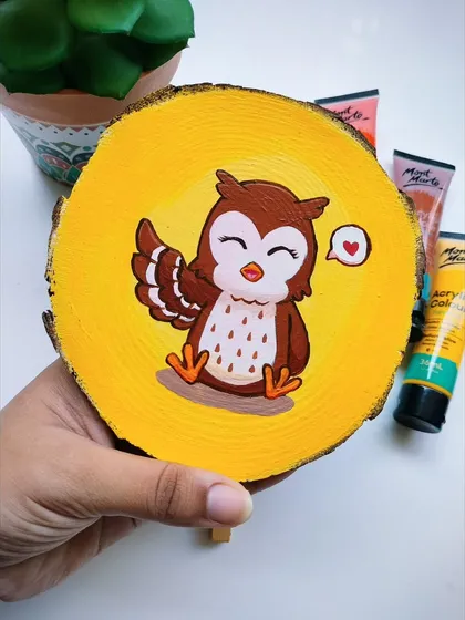 A custom-painted wooden log featuring a cute owl illustration. I use acrylics for these, and they can be personalized with a message on the back, making them a sweet and thoughtful gift.
