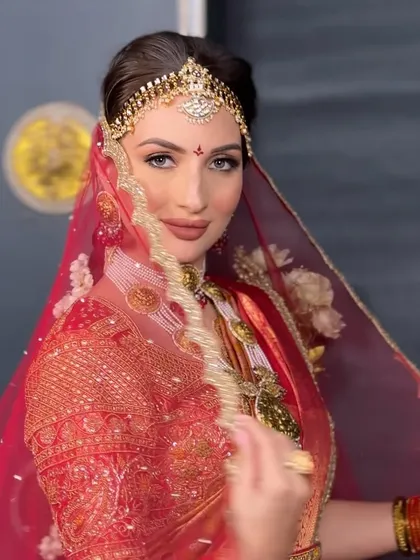 The bride under her veil, her traditional hairstyle and jewelry creating a look of timeless grace and beauty.