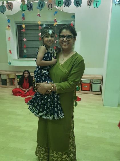 A mother holds her daughter, both dressed in lovely traditional wear, during our festive celebrations. These are the precious moments we love to capture.