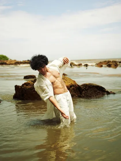 This series showcases a male model interacting with the natural beach environment. From the water to the rocks, each shot captures a different mood, perfect for an editorial story.