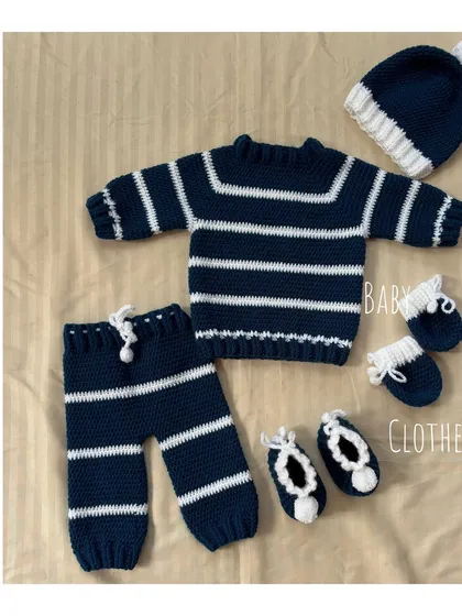 Our classic navy and white striped baby set is a perfect coming-home outfit. This complete winter collection includes a soft sweater, matching pants, a pom-pom cap, cozy mittens, and adorable booties, all handmade from warm, baby-safe wool.
