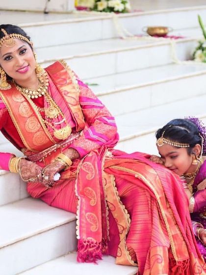 A beautiful moment captured between the bride and a little one. Dressed in her stunning red Kanjeevaram, she looks like a masterpiece of traditional art come to life.