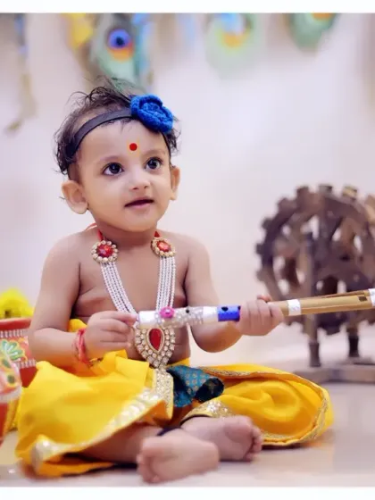 A serene moment from a baby Krishna photoshoot, featuring traditional props like a flute and painted matkis.