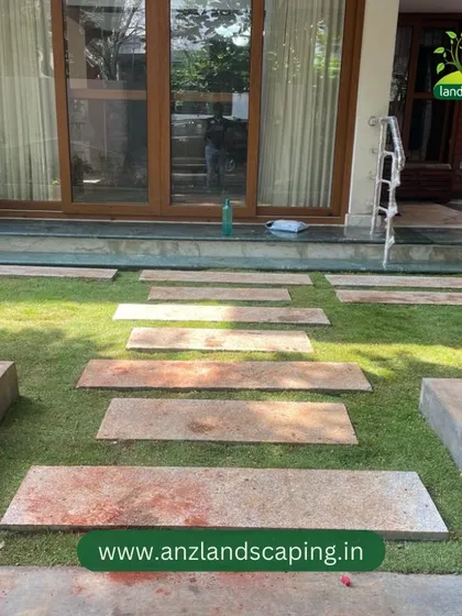 This shot focuses on the details of the hardscaping, including the stone pavers and the concrete planters that house the pathway lights and decorative elements.