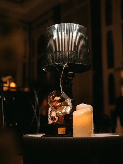 A vintage gramophone and a thick candle create a corner that whispers of timeless elegance and nostalgia, perfect for a speakeasy or classic-themed event.
