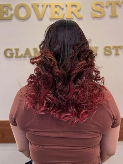 The back view of this fiery red transformation. You can see how the color catches the light in the curls, creating a beautiful, multi-tonal effect.