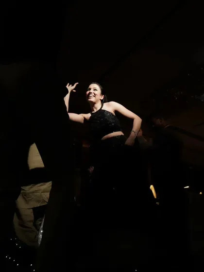 A guest dancing in the spotlight. The dramatic, dark lighting with a single focus point creates an artistic and moody party shot.