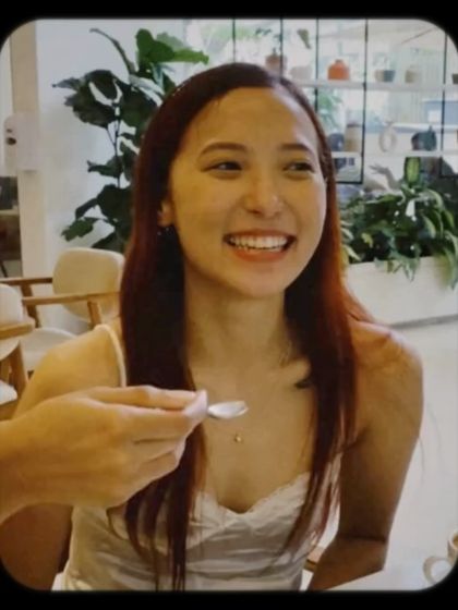 A customer's bright smile as she enjoys a treat. These are the moments we cherish.