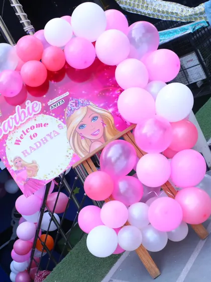 A personalized welcome sign for a Barbie-themed birthday party, surrounded by a beautiful pink and white balloon arch to greet the guests.