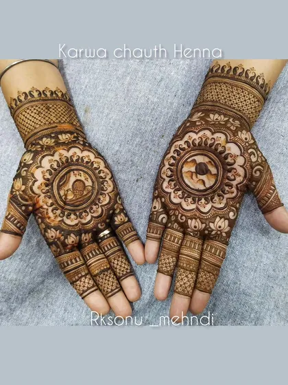This Karwa Chauth design captures the essence of devotion. The central mandala holds a traditional scene of a woman looking at the moon, surrounded by lotus details, all created to honor this special festival.