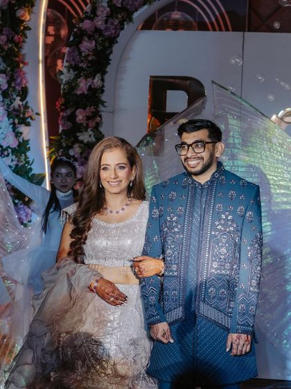 The happy couple making their entrance. Her makeup is designed to be photogenic and long-lasting, ensuring she looks her best throughout the entire event.