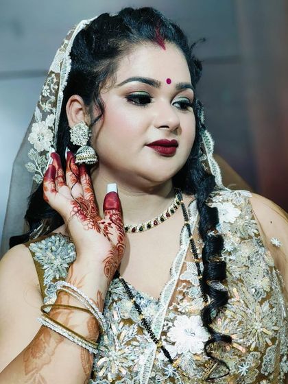 Another portrait of the happy client, highlighting her jhumka earrings and henna-adorned hand.