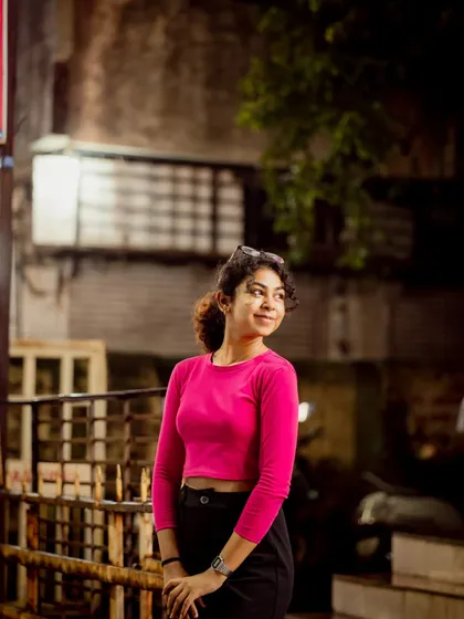 A relaxed, over-the-shoulder pose. The city lights in the background add context and depth to this street portrait.