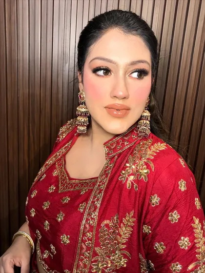 A close-up of the client's face, her glam makeup perfectly balanced by the traditional earrings.