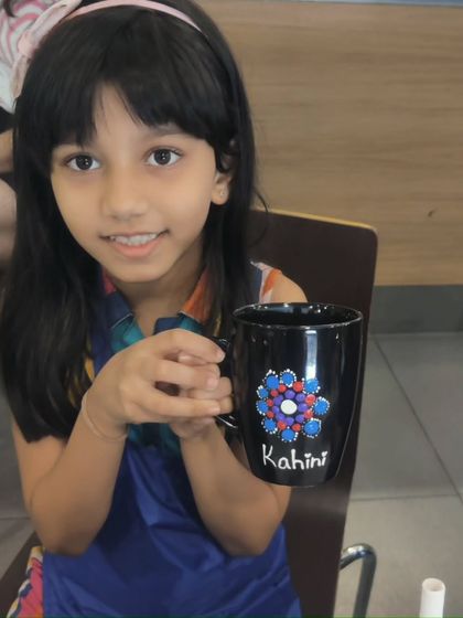 A guest at Kiara's party proudly shows her personalized mug, complete with her name, Kahini.