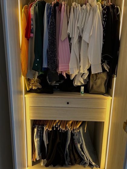 This wardrobe uses a combination of hanging space and a pull-out trouser rack to keep everything organized and wrinkle-free.