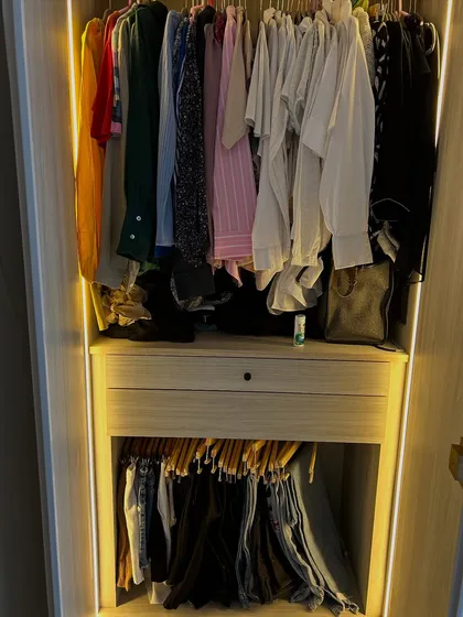 This wardrobe uses a combination of hanging space and a pull-out trouser rack to keep everything organized and wrinkle-free.