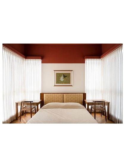 The symmetrical design of this kids' bedroom, with a central bed flanked by two study desks. The custom headboard adds a touch of pattern and personality to the serene space.