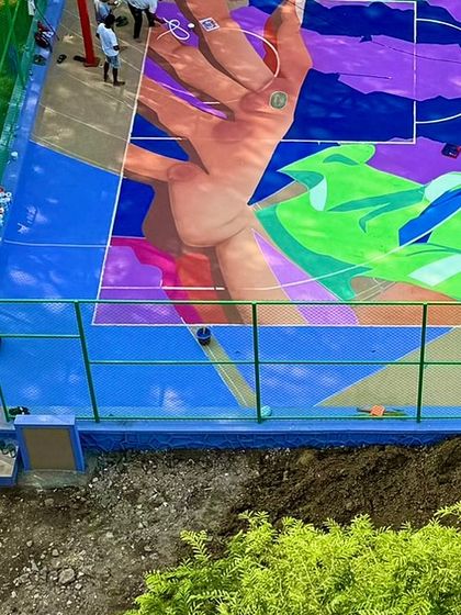 A section of the court mural coming to life, showing a hand reaching for a basketball. The design is a dynamic mix of abstract shapes and figurative elements.