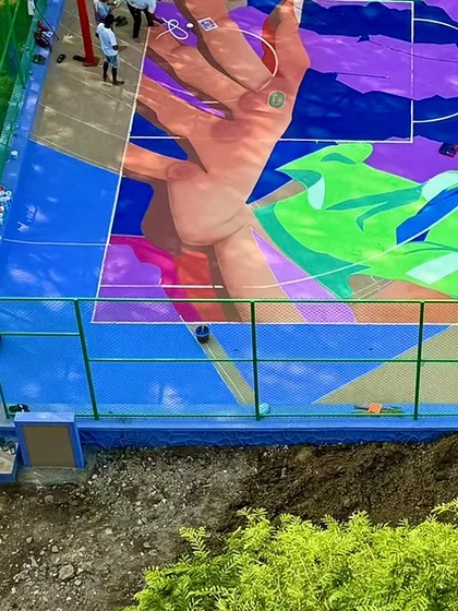 A section of the court mural coming to life, showing a hand reaching for a basketball. The design is a dynamic mix of abstract shapes and figurative elements.