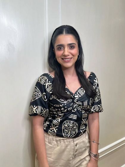 This client is the picture of satisfaction with her new look. The warm, neutral makeup tones and simple hairstyle come together to create a look of effortless elegance and comfort.