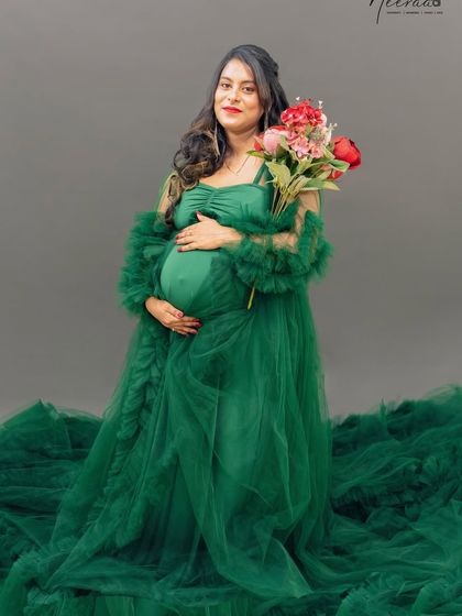 Surrounded by a sea of green tulle, this mom-to-be looks like a blooming flower herself. This is a beautiful, dreamy setup for a solo maternity portrait.