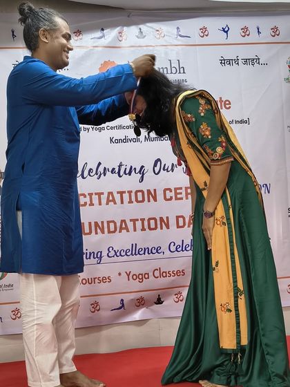 A touching moment as an instructor places a medal on a graduating student, honoring her achievement with respect and blessings.