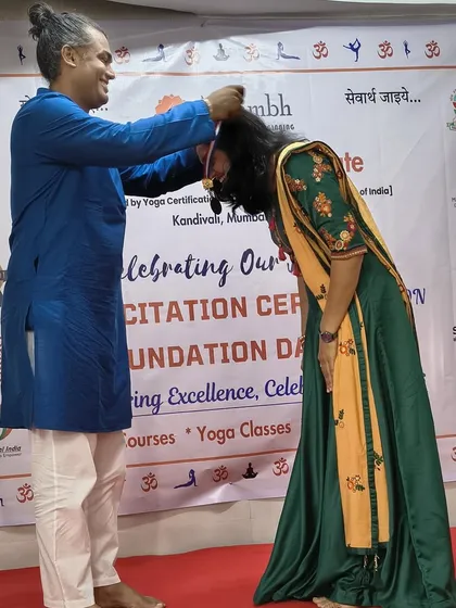 A touching moment as an instructor places a medal on a graduating student, honoring her achievement with respect and blessings.