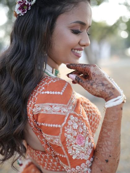 A side profile showcasing the soft curls and the intricate details of her blouse. The makeup highlights her features beautifully.