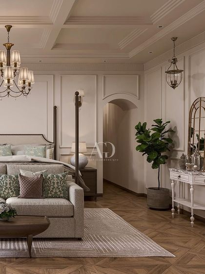 A cozy corner in a classic bedroom, featuring a comfortable sofa and distressed-finish console table. The herringbone wood floor and paneled walls provide a beautiful, textural backdrop.