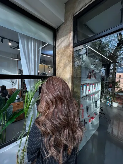 This lived-in hair color is all about creating soft, natural-looking dimension. The highlights are carefully placed to mimic how the sun would naturally lighten the hair.