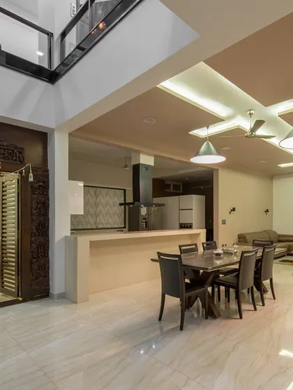 A seamless blend of modern living and traditional values in this Bangalore residence. The open-plan dining and kitchen area flows effortlessly, while the intricately carved wooden doors of the puja room stand as a beautiful, sacred focal point, grounding the contemporary design in cultural heritage.