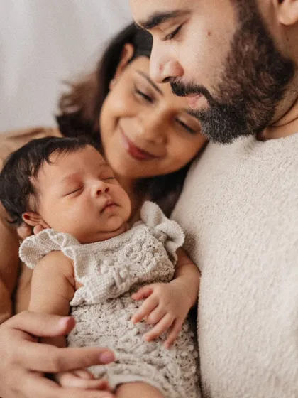 The quiet, powerful love of new parents. This intimate close-up captures a mother and father cherishing their sleeping newborn, showcasing the soft, emotional style of my newborn family portraits.