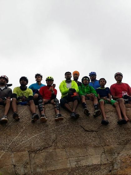 The full line-up of riders sitting on a rock, showcasing the size and diversity of our group.