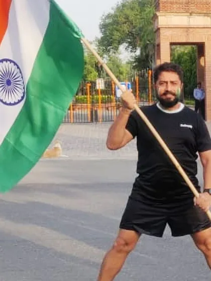 A member striking a powerful pose with the Indian flag. We are strong, proud, and passionate about our country.
