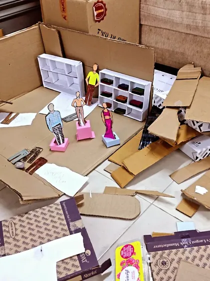 A miniature diorama made from cardboard boxes. Our volunteers are incredibly resourceful, turning everyday waste into valuable teaching tools for vocational training.
