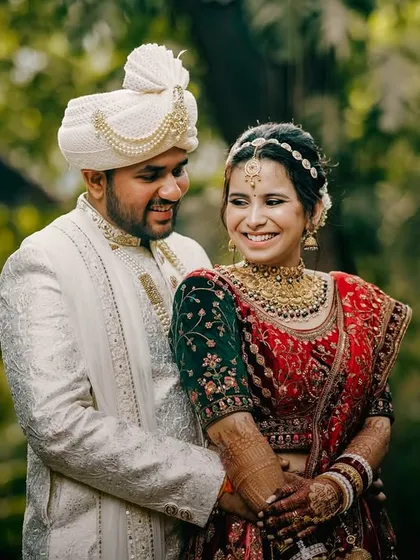 A classic portrait of the couple in a lush garden setting. The groom's embrace and their joyful expressions create a timeless and romantic image of their wedding day.