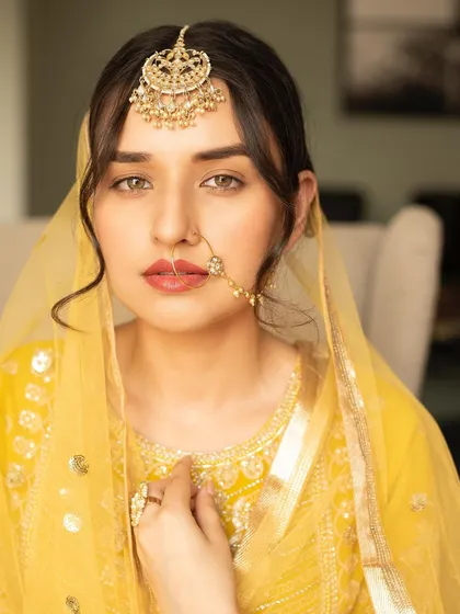 A close-up of the Heeramandi look, highlighting the nude-toned lipstick, sharp winged eyeliner, and the traditional nose ring.