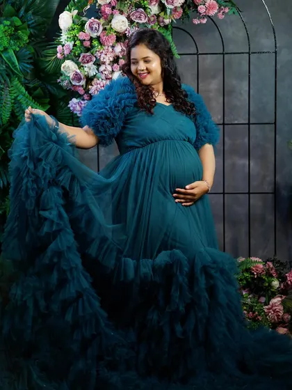 For all the moms-to-be, we have a special collection of maternity photoshoot gowns. This beautiful client is wearing our flowy teal tulle gown, designed for both comfort and style to capture this precious time in your life.