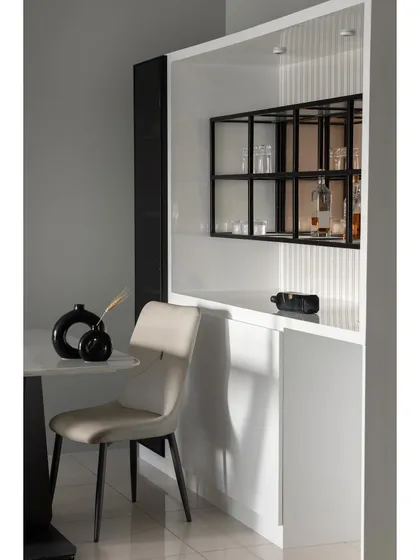 This detail shot highlights the custom bar and crockery unit. The design features a mix of open and closed storage, with a black metal grid shelf for displaying glassware, set against a white fluted backdrop.