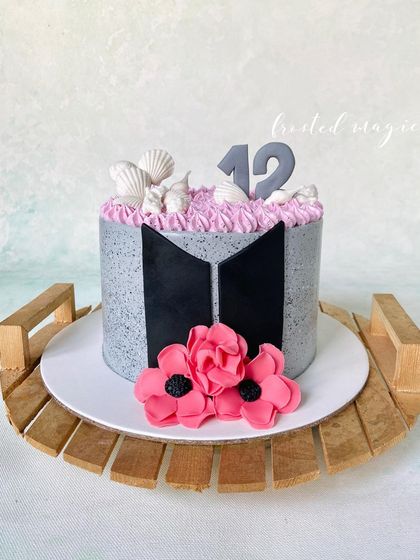 For the BTS Army! This is a non-fondant cake with a mosaic finish in the band's signature colors. It's accented with the BTS logo and handmade sugar flowers for a touch of elegance.