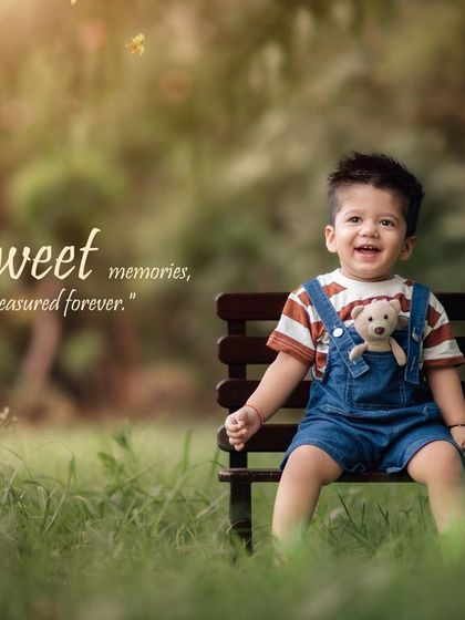 Sweet memories, treasured forever. This happy boy in overalls shares a moment with his teddy bear on a park bench.